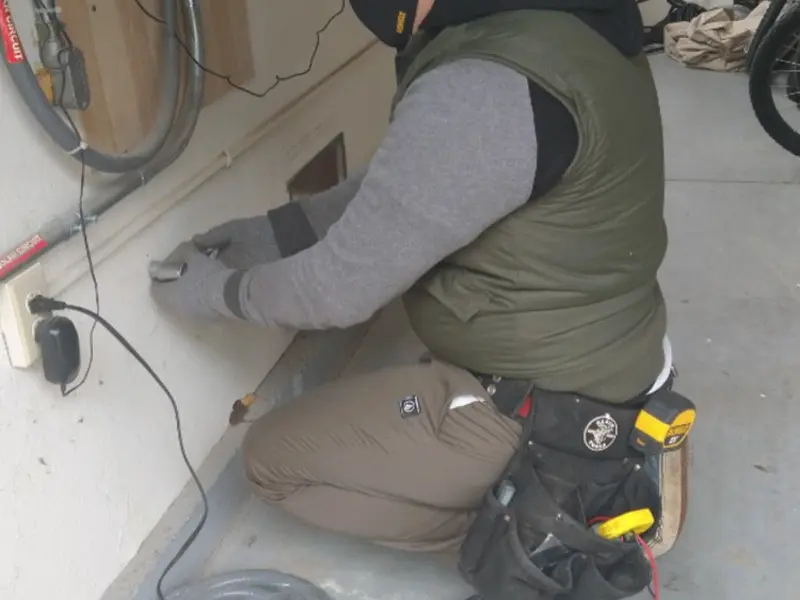 Electrician performing outlet wiring in a Barrett garage